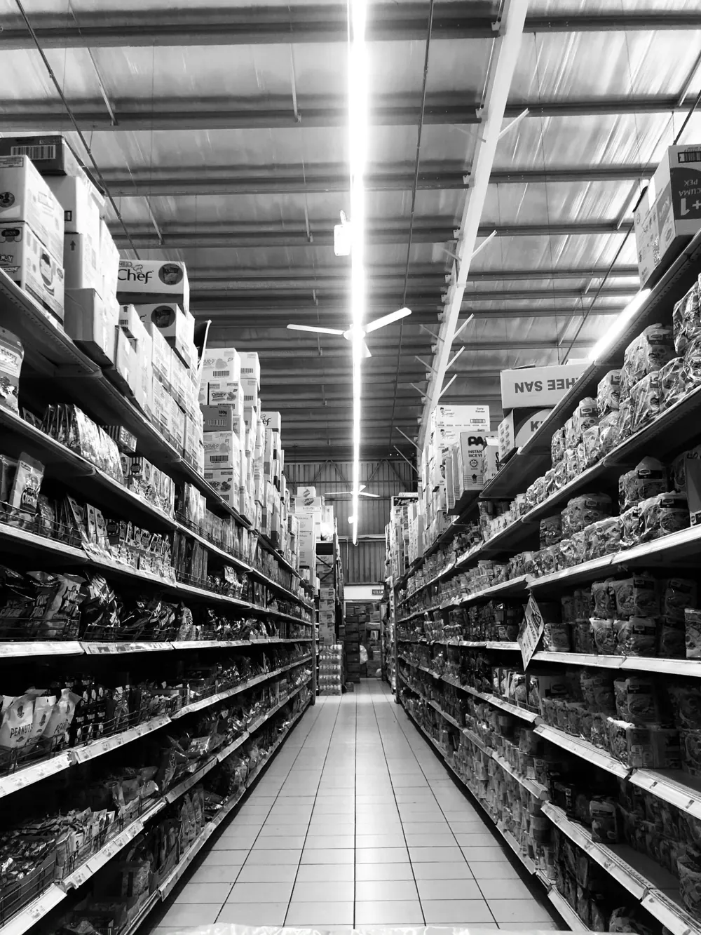 Corredor de supermercado com prateleiras organizadas — controle de estoque na loja